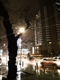 Illuminated city street against sky at night