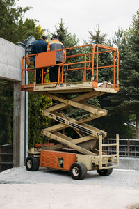 Scissor lift platform with workers on a construction site. building concreate house with mobile