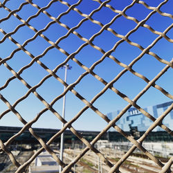 Full frame shot of chainlink fence against blue sky