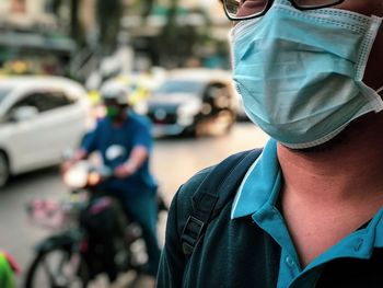 Close-up of man wearing surgical mask on street
