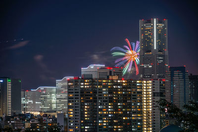 Illuminated modern buildings against sky at night