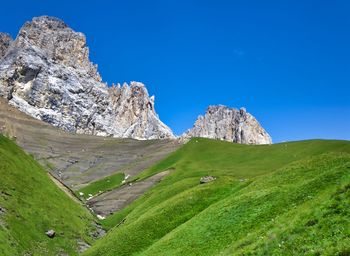Scenic view of rocky mountains against blue sky