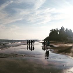 People on beach against sky