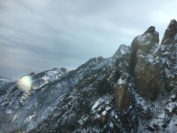 Low angle view of snowcapped mountain against sky