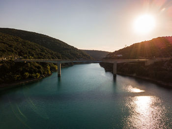 Scenic view of lake and bridge against sky during golden hour