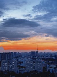 Aerial view of city against cloudy sky during sunset