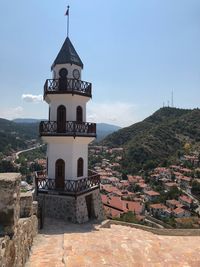 Tower amidst buildings in town against sky