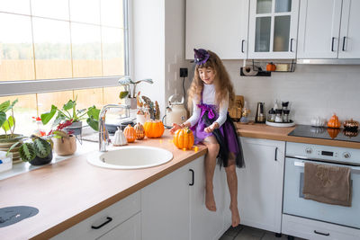 Side view of woman washing hands in kitchen