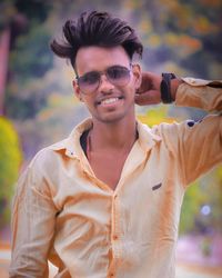 Portrait of young man wearing sunglasses while standing outdoors