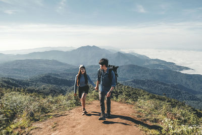 Couple on mountain against sky