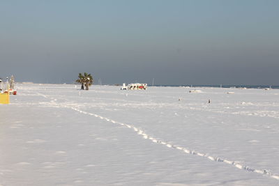 Scenic view of snow covered beach against sky during winter