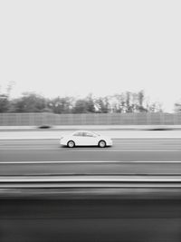 Blurred motion of car on road against clear sky