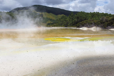 Scenic view of hot spring against mountains