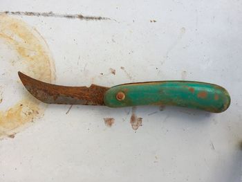 Close-up of rusty metal on wood against wall
