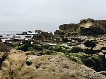 Rocks on beach against sky