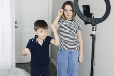 Boy and girl making dance tutorial at home