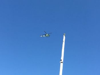 Low angle view of airplane against clear blue sky