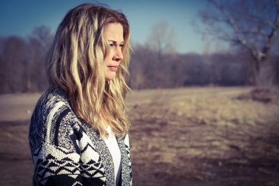 Portrait of young woman standing on field