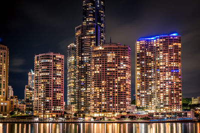 Illuminated buildings against sky at night