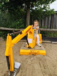 Boy sitting on yellow cart