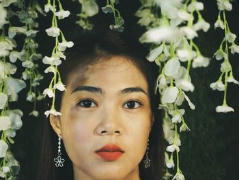 Close-up portrait of woman amidst white flowers