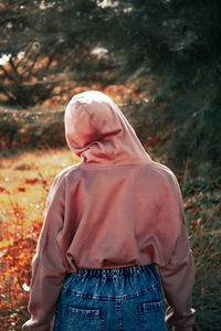 Rear view of woman standing on field