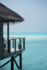 Lifeguard hut on beach against clear blue sky