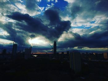 Silhouette of buildings against cloudy sky