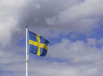 Low angle view of flag against cloudy sky