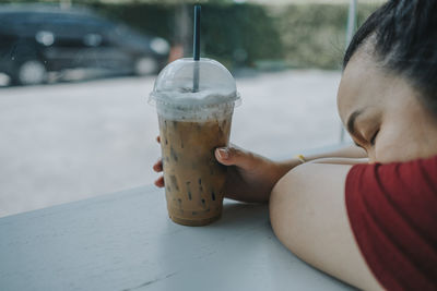 Close-up portrait of boy drinking glass on table