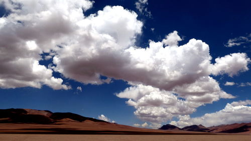 Low angle view of desert against blue sky