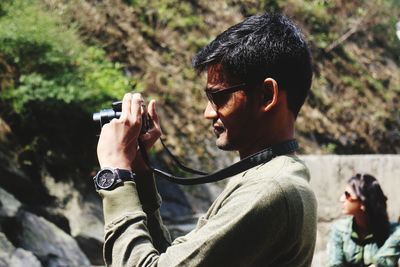 Close-up of man photographing through camera