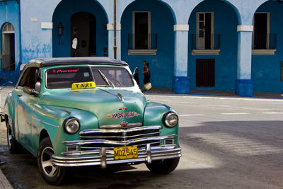 Vintage car on street against buildings in city