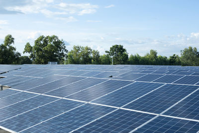 Solar panels on field against sky