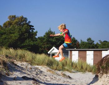 Boy jumping against clear sky