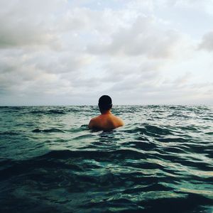 Rear view of man swimming in sea