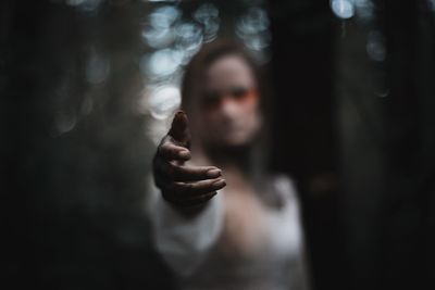 Woman gesturing while standing in forest