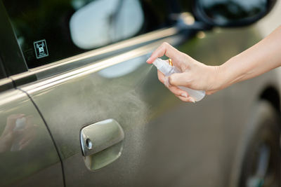 Midsection of person holding smart phone in car