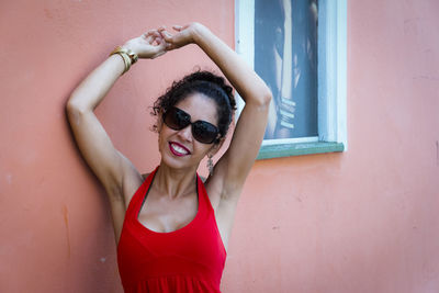 Portrait of a woman wearing red clothes on the street in bright sunny day. 