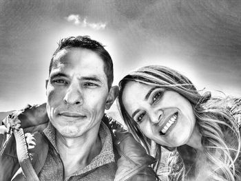 Portrait of smiling young woman against sky