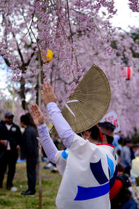 Rear view of people holding cherry blossom