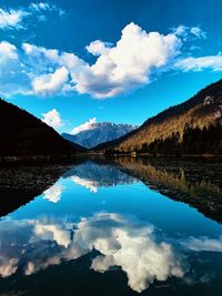 Scenic view of lake by mountains against sky