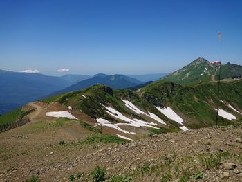 Scenic view of mountains against clear blue sky