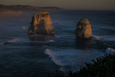 Rock formation in sea against sky