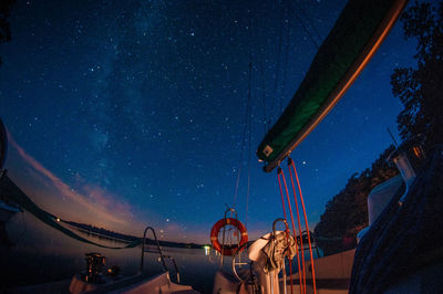 Low angle view of illuminated lights against clear blue sky