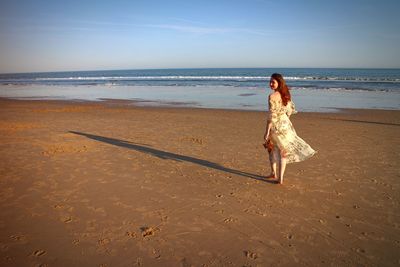 Full length of woman on beach against sky