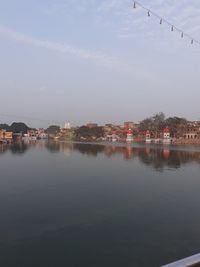 Scenic view of lake by buildings against sky