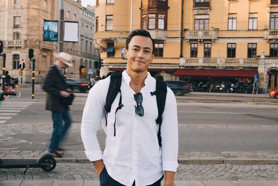 Portrait of man standing on street in city