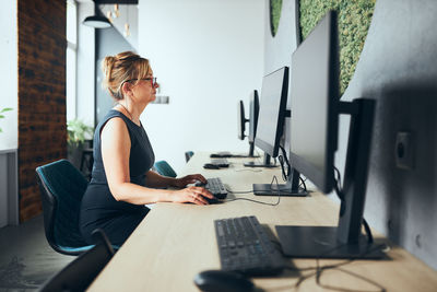 Concerned businesswoman working on computer in office. busy woman sitting at desk at front of screen