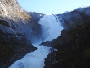 Scenic view of waterfall against sky